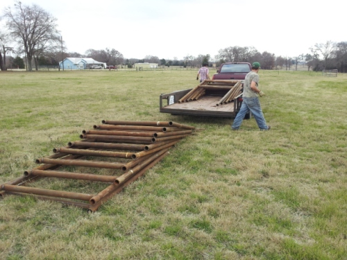 Unloading VSP Trellis for vine wire.  Average weight 300 lbs.  Hole for each nine inches each.  Will encompass an acre and a half.  Copyright 2015 John J. Rigo, Stewart-Rigo Winery in Eustace, Texas. 